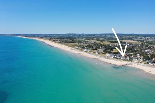 - une vue aérienne sur une plage avec un moulin à vent dans l'établissement Villa bord de mer pour 10 personnes, à Portbail
