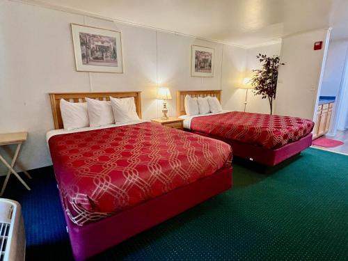 um quarto de hotel com duas camas com capas vermelhas em Rodeway Inn & Suites Brunswick near Hwy 1 em Brunswick
