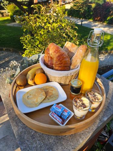 una bandeja de pan y otros alimentos en una mesa en Les Rauches - Quai Loire - Suite Love, en Châteauneuf-sur-Loire