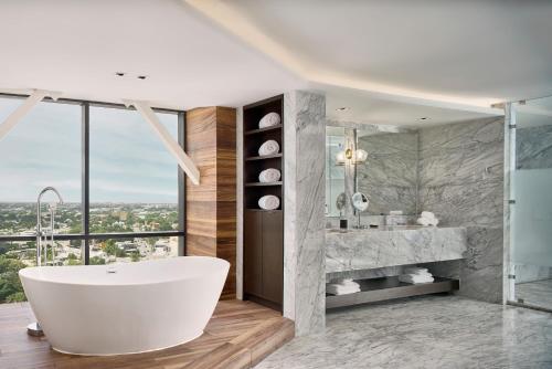 Hyatt Regency Merida في ميريدا: حمام مع حوض استحمام و نافذة كبيرة