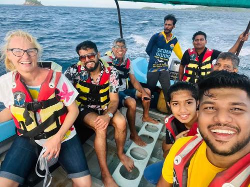 a group of people sitting on a boat in the water at Nilaveli Guest House in Nilaveli