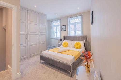 a bedroom with a bed with yellow pillows on it at Spacious 3BR Home by D3 Short Stay, Sleep 9, Free WIFI & Parking in London