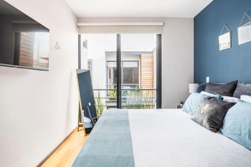 a bedroom with a large bed with blue walls at New PH for 6, BBQ and amazing private roof terrace in Mexico City