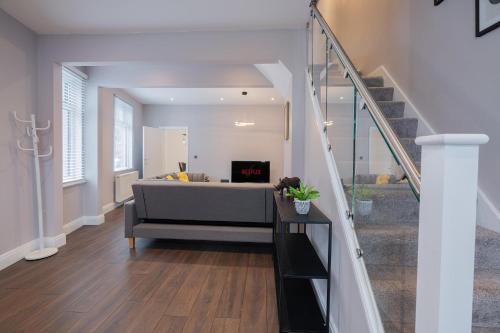 a living room with a couch and a staircase at Spacious 3BR Home by D3 Short Stay, Sleep 9, Free WIFI & Parking in London