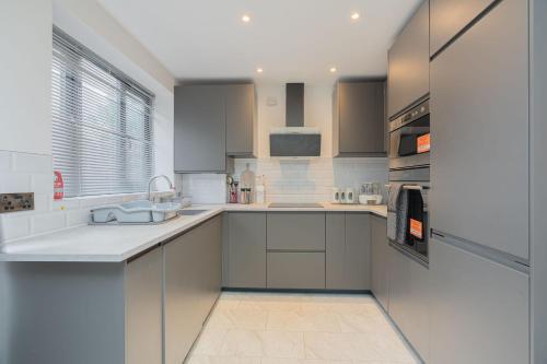 a kitchen with a sink and a counter top at Spacious 3BR Home by D3 Short Stay, Sleep 9, Free WIFI & Parking in London