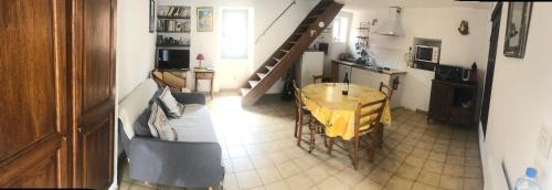Il dispose d'une cuisine et d'un salon avec une table et un escalier. dans l'établissement MAISON DE VILLAGE AUREL, à Aurel