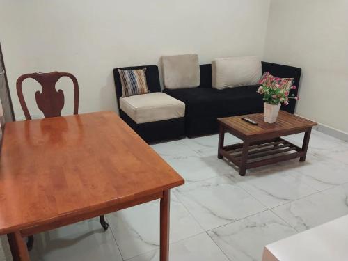 Tulba Hotel and Residences في جوبا: غرفة معيشة مع أريكة وطاولة