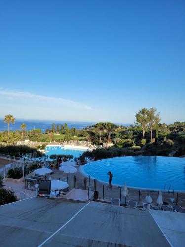 une personne debout en face d'une piscine dans l'établissement Cap Esterel en famille - 2pièces vue mer jardin piscine clim parking inclus, à Saint-Raphaël