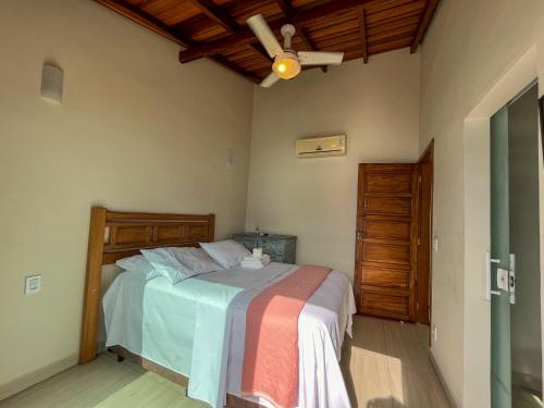 um quarto com uma cama e uma ventoinha de tecto em Bela casa c/ vista privilegiada, à 1km da Ilha das Cabras em Ilhabela