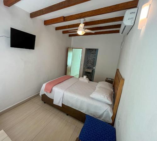 um quarto com uma cama e uma televisão de ecrã plano em Bela casa c/ vista privilegiada, à 1km da Ilha das Cabras em Ilhabela