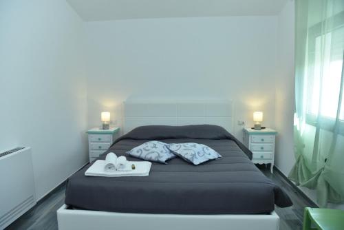 a bedroom with a bed with two towels and two night stands at Rosa dei Venti ROOMS in Abbasanta