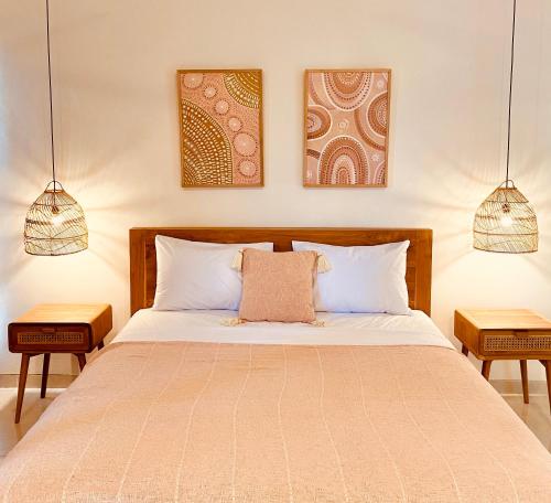 a bedroom with a large bed with two lamps at The Hideaway Canggu in Canggu