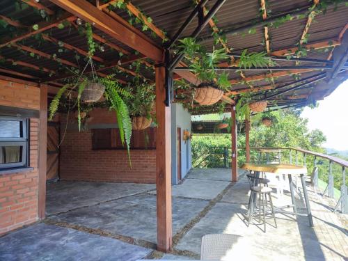 a patio with a wooden pergola with chairs and plants at Pistacho in Minca