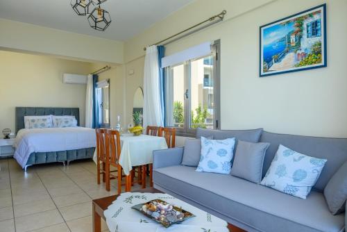 ein Wohnzimmer mit einem Sofa und einem Bett in der Unterkunft Perla Apartments in Agios Nikolaos