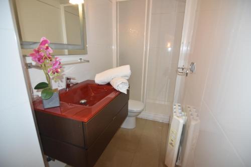 uma casa de banho com um lavatório vermelho e um WC. em RNET Apartments Roses Duplex Granada em Roses