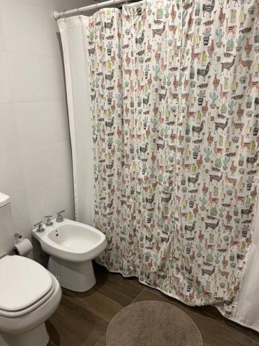 a bathroom with a toilet and a shower curtain at El loft mas lindo de Cafayate! in Cafayate