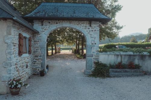 une arche dans un bâtiment en pierre avec une allée dans l'établissement Gîte Peyré - Michel & Geneviève, à Lasseube