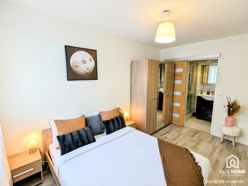 a bedroom with a large bed and a bathroom at Le Cocon - Lumineux - Grande TV - Parking gratuit in Fleury-les-Aubrais