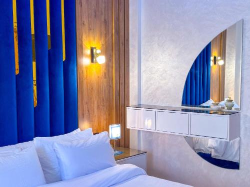 a bedroom with a white bed and a mirror at VELUXA - LUXURY HOLIDAY HOMES - Centric flat in Tangier