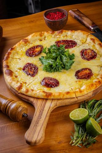 a pizza sitting on top of a wooden table at DiliJazz Hotel & Restaurant in Dilijan