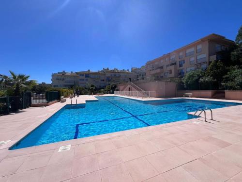 une grande piscine avec de l'eau bleue dans un immeuble dans l'établissement Studio, piscine, parking, à Saint-Tropez