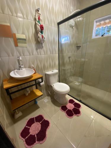 a bathroom with a toilet and a shower and a sink at Refúgio do Tucano in Alto Paraíso de Goiás