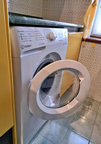 a washing machine with its lid up in a bathroom at La Dimora del Centro in Iesi
