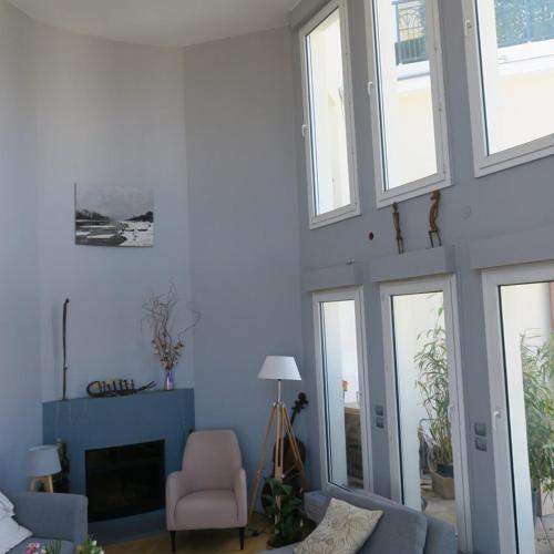 d'un salon avec des murs et des fenêtres bleus. dans l'établissement Paris La Défense à 15min Champs Elysées - 140m2 avec terrasse 31m2 au dernier étage, à Courbevoie