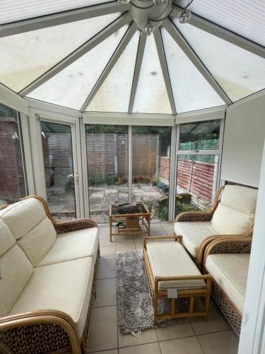 a conservatory with two couches and a glass roof at Campbell House in Birmingham