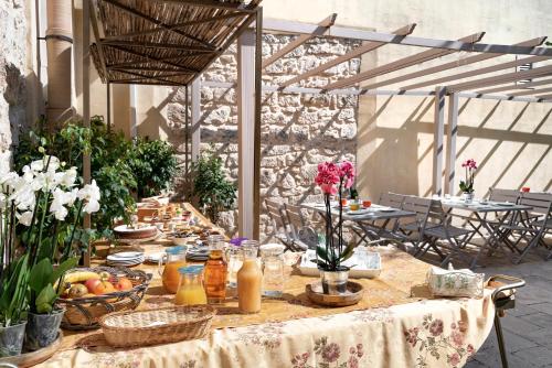una mesa larga con comida y flores. en Baglio donna Concetta en Noto