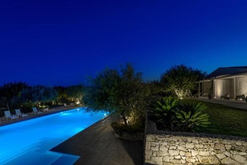 a swimming pool in front of a house at night at Baglio donna Concetta in Noto