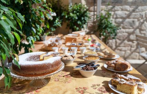 a long table with cakes and pastries on it at Baglio donna Concetta in Noto