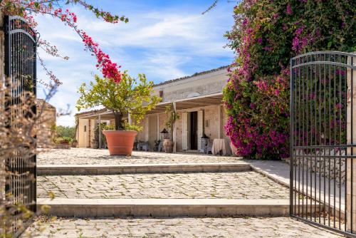 a gate in front of a house with flowers at Baglio donna Concetta in Noto