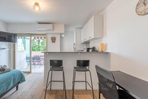 une cuisine et une salle à manger avec une table et des chaises dans l'établissement Studio avec terrasse vue jardin, à Antibes