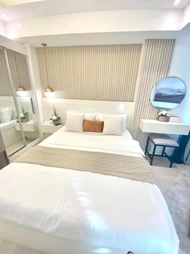 Una habitación de hotel con dos camas y un espejo. en Alexis Place Azure North, en San Fernando