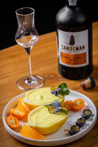 a plate of fruit with a bottle of wine and a glass at DiliJazz Hotel & Restaurant in Dilijan