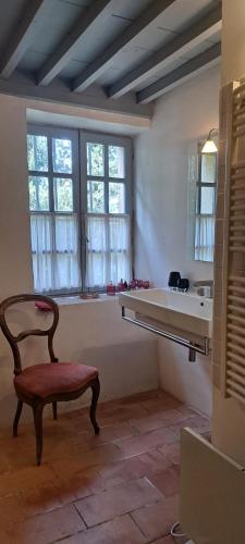 a room with a chair and a sink and window at Le Mas du Lac in Uzès