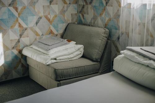 una silla con un montón de toallas en una habitación en Apartamenty Leśna, en Limanowa