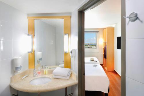 a bathroom with a sink and a large mirror at Ibis Cancun Centro in Cancún