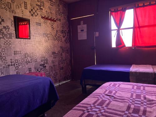 Habitación con 2 camas y ventana en Paracas Camp Lodge & Experiences, en Paracas