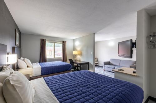 a hotel room with two beds and a flat screen tv at Freer Executive Inn & Studios in Freer
