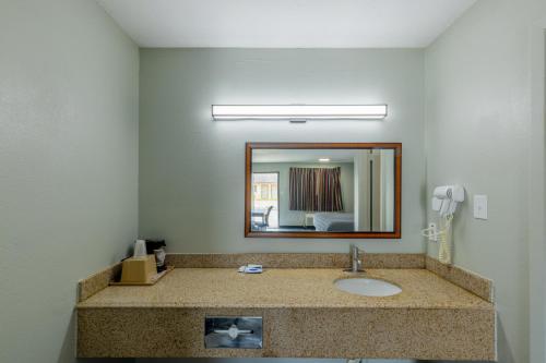 a bathroom with a sink and a mirror at Freer Executive Inn & Studios in Freer