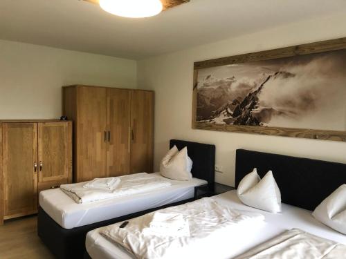 a room with two beds and a painting on the wall at Appartements Domizil in Kaprun