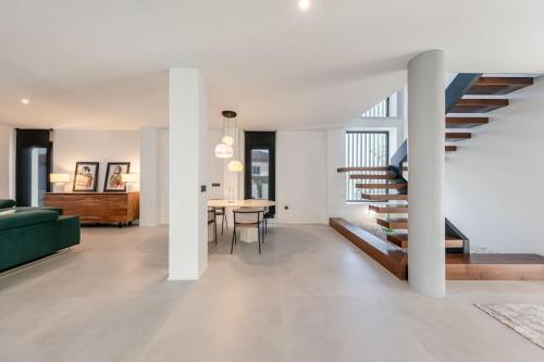 ein Wohnzimmer mit einer grünen Couch und einer Treppe in der Unterkunft Villa con Piscina Privada in Gelves