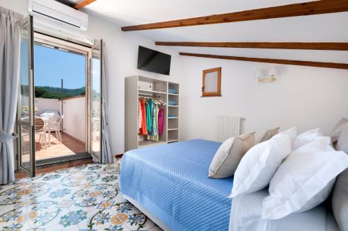 um quarto com uma cama azul e uma varanda em YourHome - Jolly Pini Apartment em Sant'Agnello