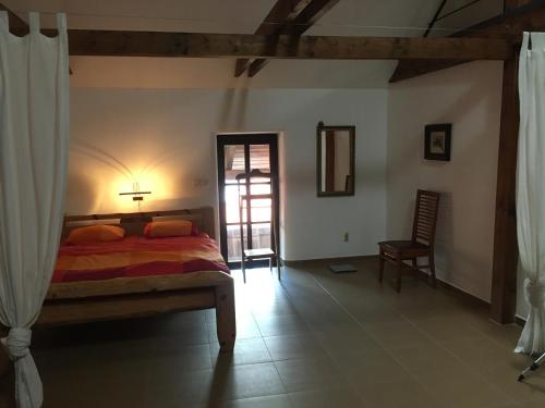 a bedroom with a bed with a lamp and a chair at Holubník statečných žen králových in Luže