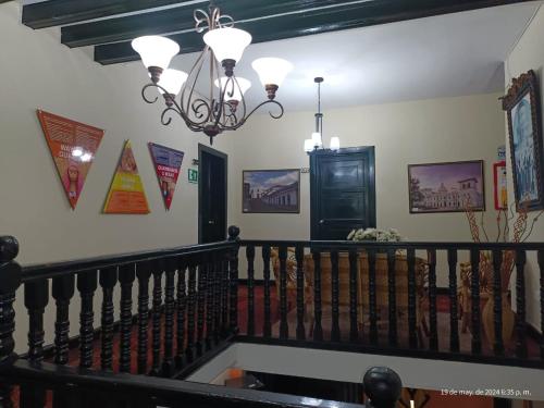 a hallway with a staircase with a chandelier at Hotel La Herreria Colonial in Popayan