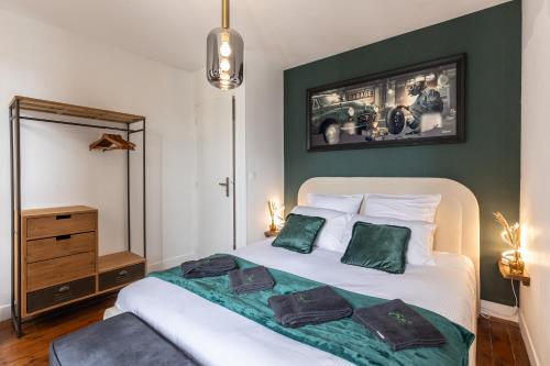 une chambre avec un lit avec deux oreillers verts dans l'établissement Pont'Au Centre - Cosy - B'PAM, à Pont-Audemer