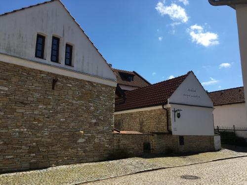 a building with a brick wall and a white building at Holubník statečných žen králových in Luže