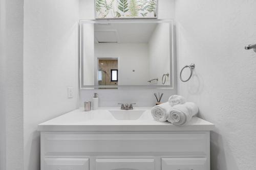 a white bathroom with a sink and a mirror at Westchester Garden in Miami